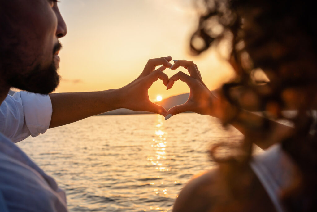 young couple making a heart shape with their hands on Valentine's Day.